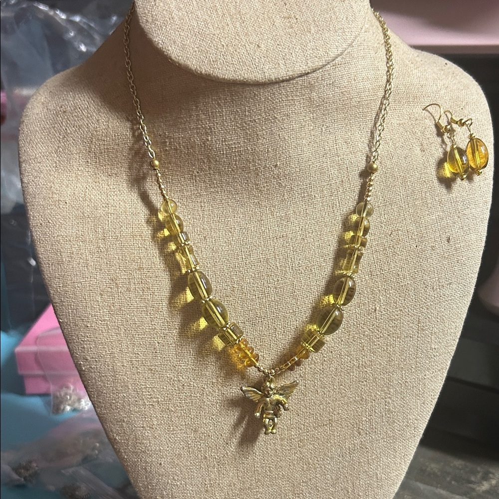 vintage costume set amber-colored glass beads and a gold-tone cherub pendant.